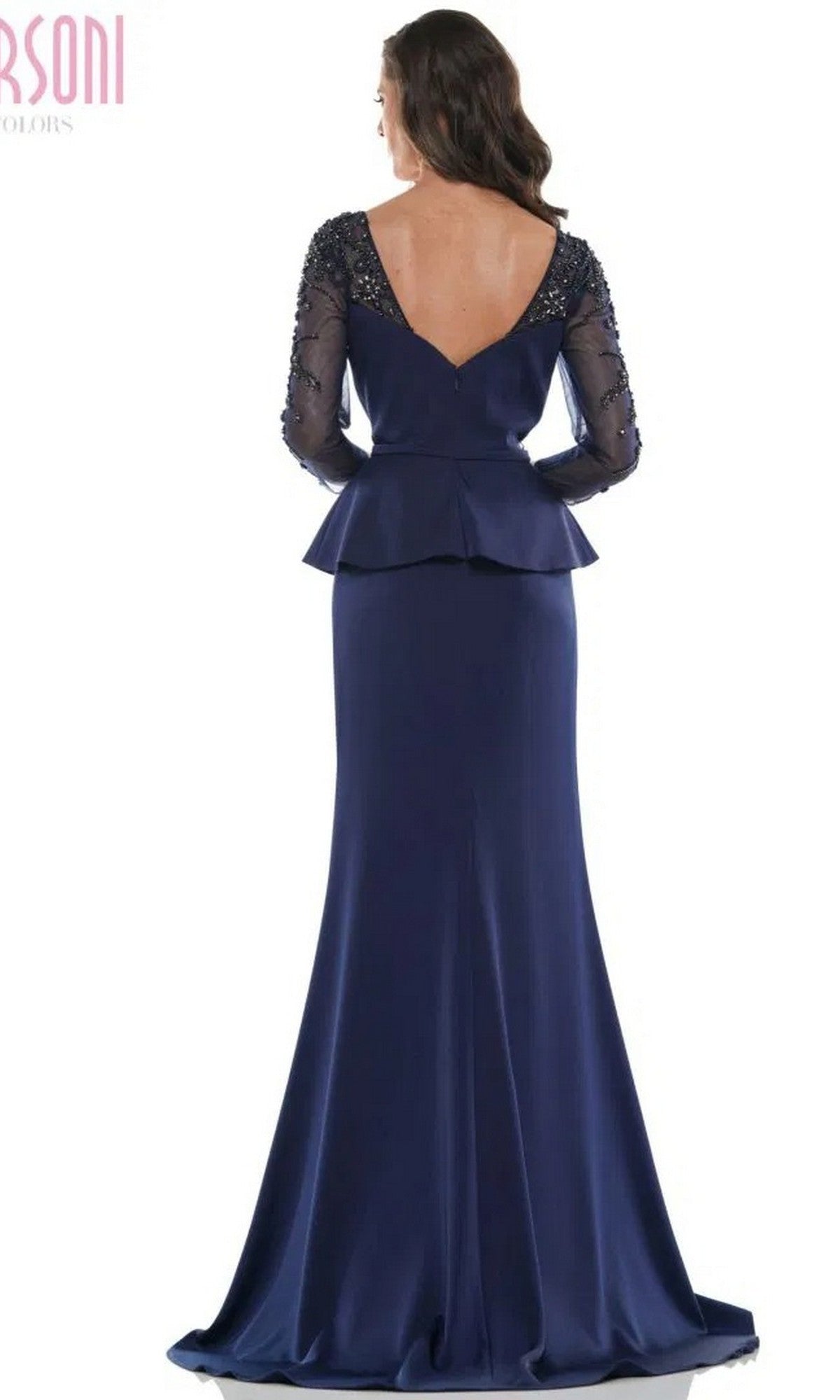 Woman in the Marsoni MV1037 long formal dress—a navy blue, floor-length embellished trumpet gown with long beaded sleeves, peplum waist, and deep V-back—stands facing away from the camera.